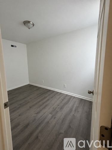 A room with a wooden floor and a white door.