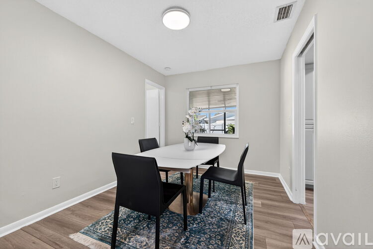 A dining room with a table and chairs.