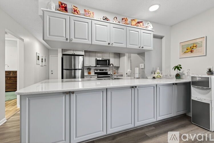 A kitchen with white cabinets and a white countertop.