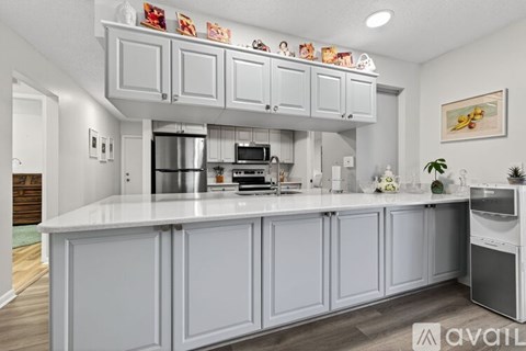 A kitchen with white cabinets and a white countertop.