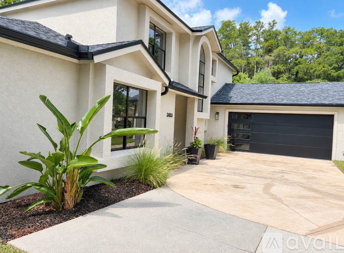 A modern house with a driveway and landscaping.