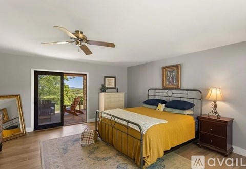 A bedroom with a bed, dresser, and a ceiling fan.