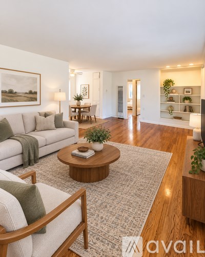 A living room with a white couch, a wooden coffee table, and a painting on the wall.