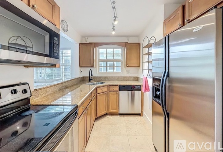 A kitchen with a stainless steel refrigerator, microwave, and oven.