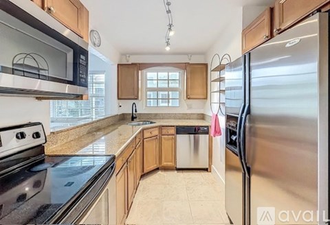 A kitchen with a stainless steel refrigerator, microwave, and oven.