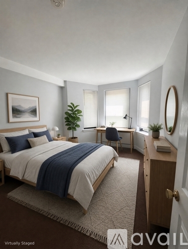 A bedroom with a bed, desk, and chair.