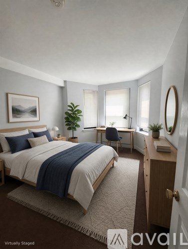 A bedroom with a bed, desk, and chair.