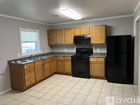 A kitchen with wooden cabinets and black appliances.