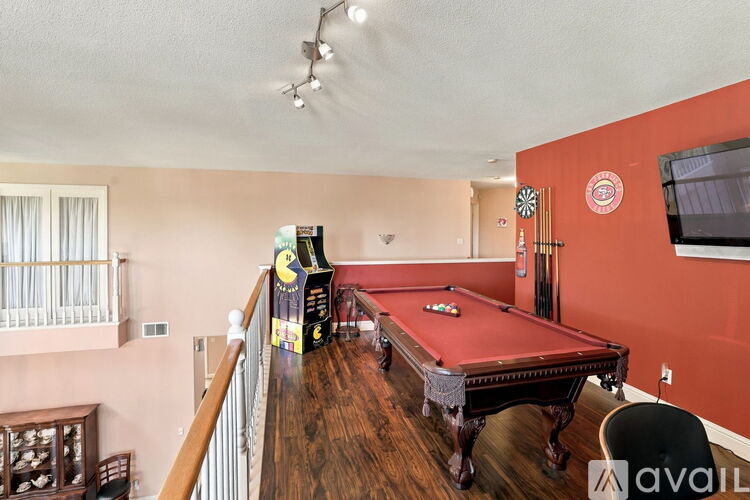 A pool table in a room with a balcony.