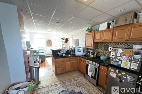 A kitchen with wooden cabinets and a black fridge.