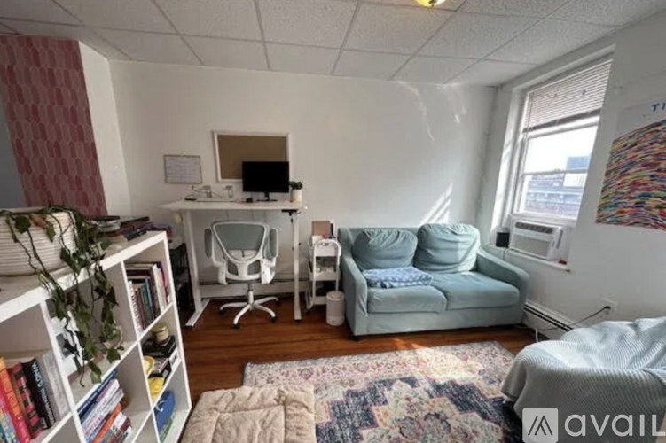 A living room with a couch, chair, and a bookshelf.
