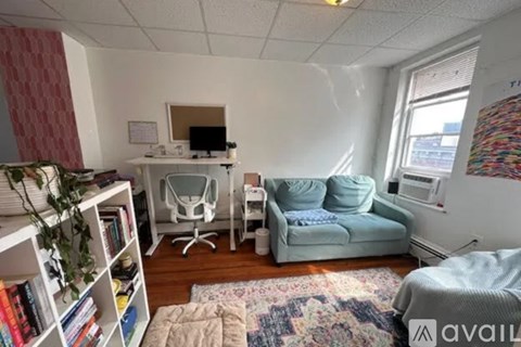 A living room with a couch, chair, and a bookshelf.