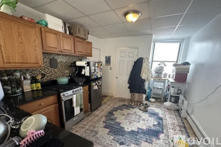 A kitchen with a black stove top and a black refrigerator.