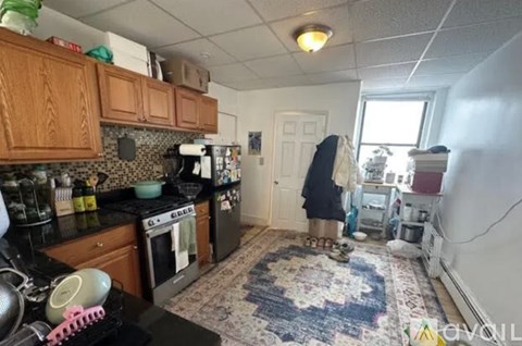 A kitchen with a black stove top and a black refrigerator.