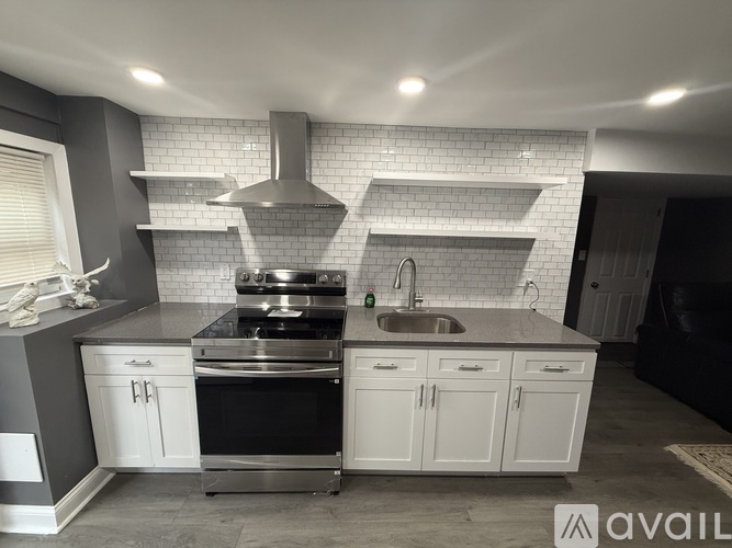 A modern kitchen with a stainless steel oven and white cabinets.