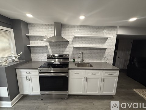 A modern kitchen with a stainless steel oven and white cabinets.