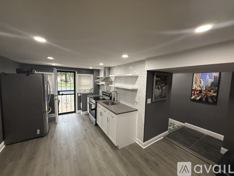 A kitchen with a refrigerator, sink, and cabinets.