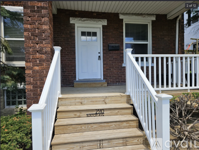 A house with a white door and a wooden staircase leading to it.
