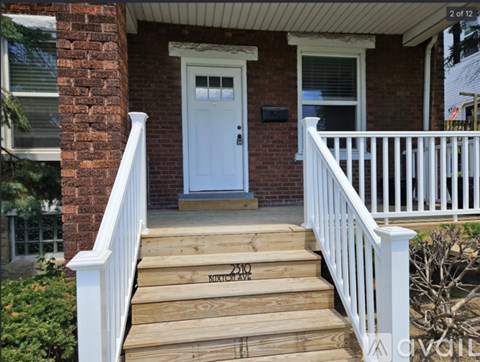 A house with a white door and a wooden staircase leading to it.