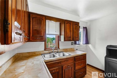 A kitchen with wooden cabinets and a marble countertop.