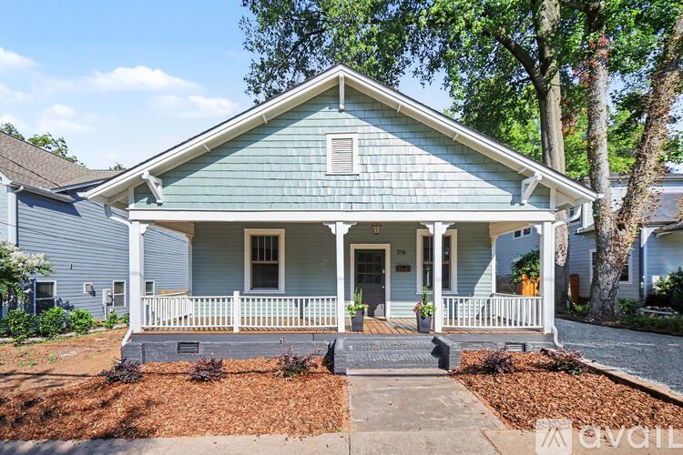 A blue house with a porch and a small front yard.