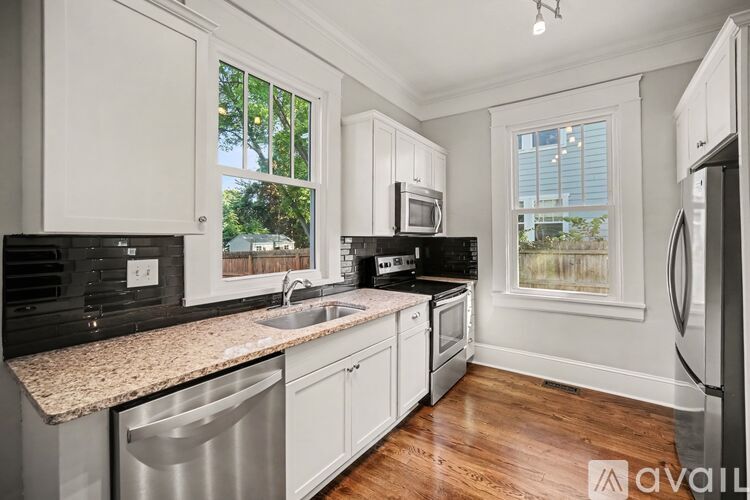 A kitchen with white cabinets and a granite countertop.