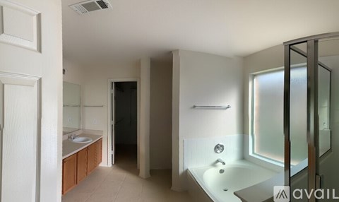 A bathroom with a white tub and a walk-in shower.