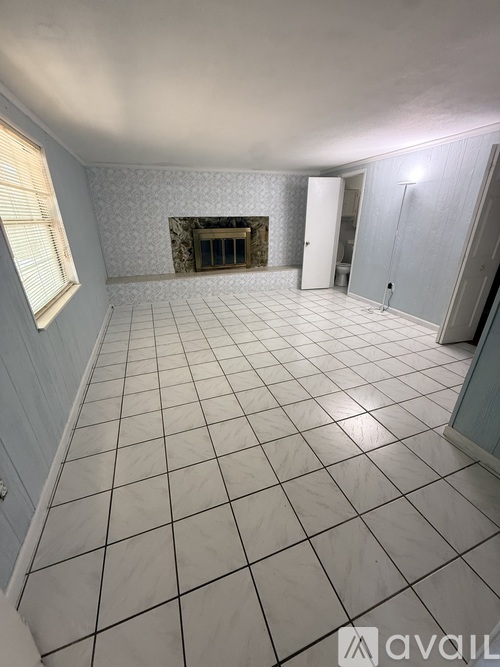 A room with a fireplace and tiled flooring.