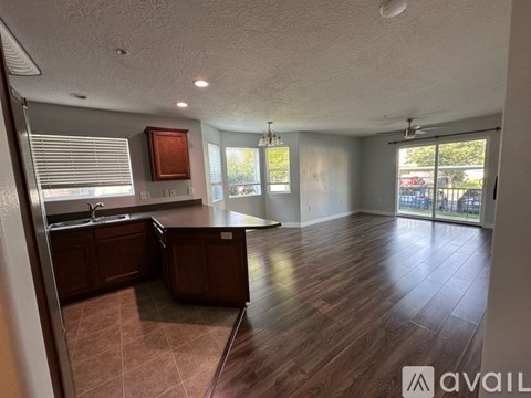 A kitchen with wooden cabinets and a large open space.