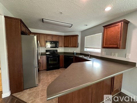 A kitchen with brown cabinets and a stainless steel refrigerator.