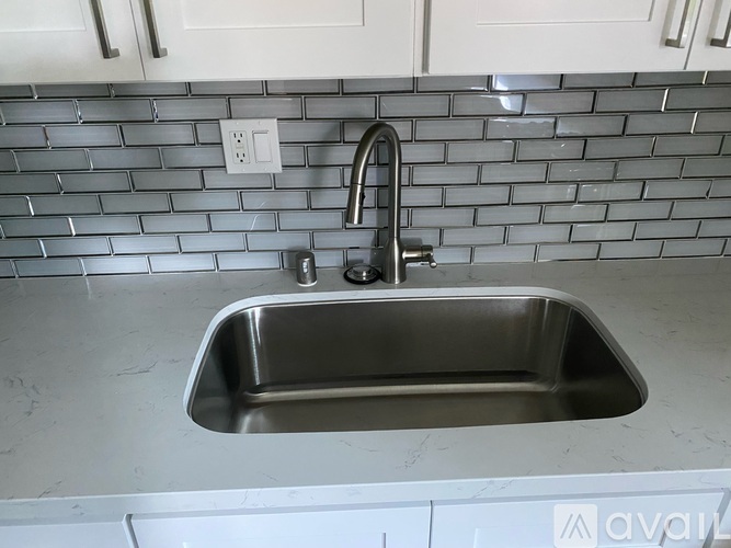 A stainless steel kitchen sink with a faucet.