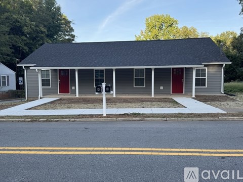 A small house with a red door is for sale.