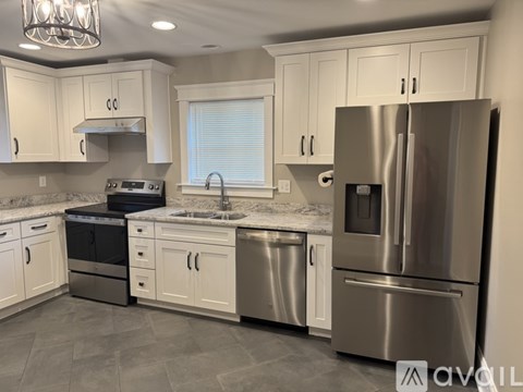 A modern kitchen with stainless steel appliances and white cabinets.