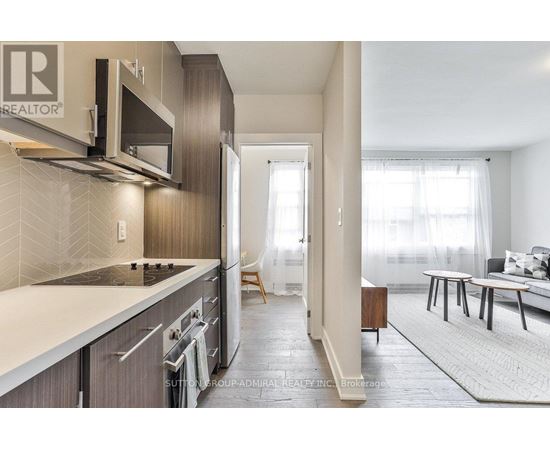 A modern kitchen with dark wood cabinets and a white countertop.