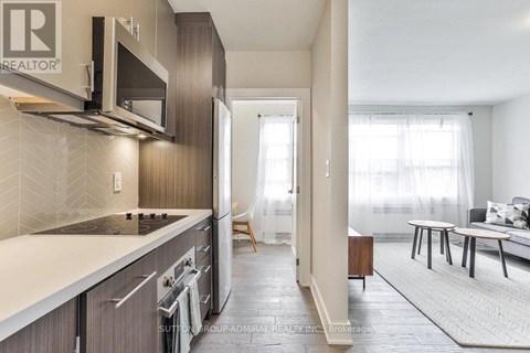 A modern kitchen with dark wood cabinets and a white countertop.