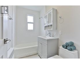 A white bathroom with a toilet, sink, and bathtub.