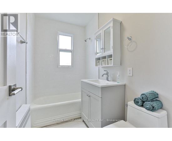 A white bathroom with a toilet, sink, and bathtub.