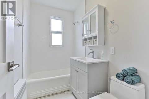 A white bathroom with a toilet, sink, and bathtub.
