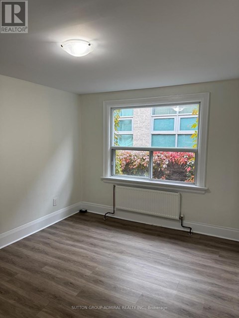 A room with a window and a radiator on the floor.