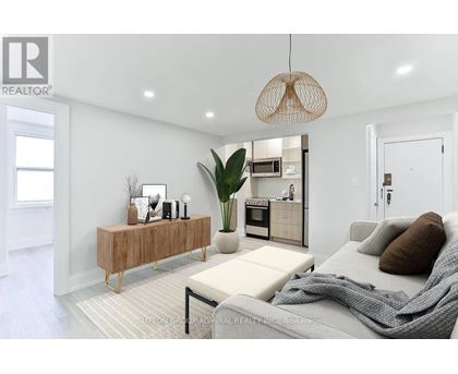 A modern living room with a grey sofa and a wooden cabinet.