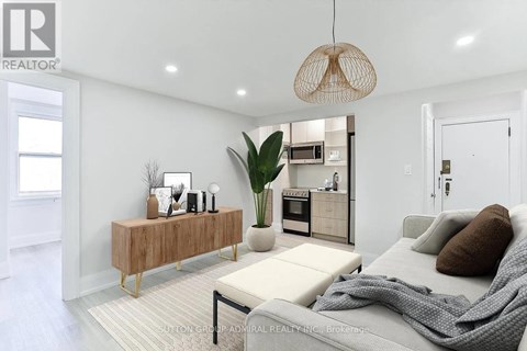 A modern living room with a grey sofa and a wooden cabinet.