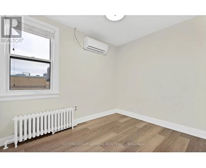 A room with a window, a radiator, and a ceiling light.