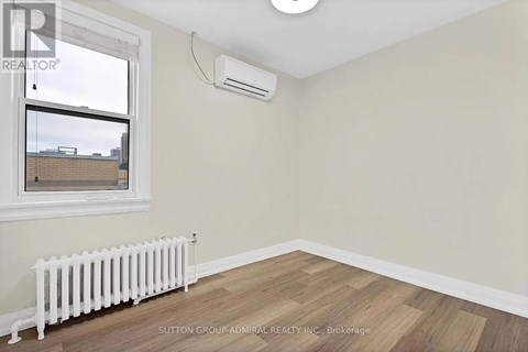 A room with a window, a radiator, and a ceiling light.