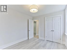 A white door is open in a room with a light on the ceiling.