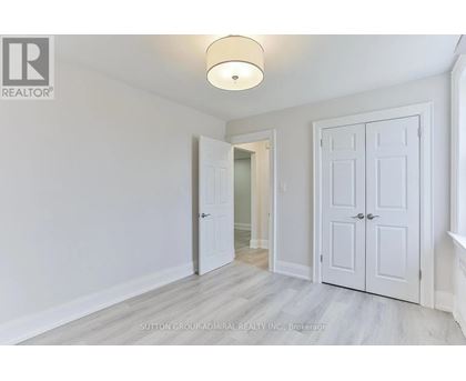 A white door is open in a room with a light on the ceiling.