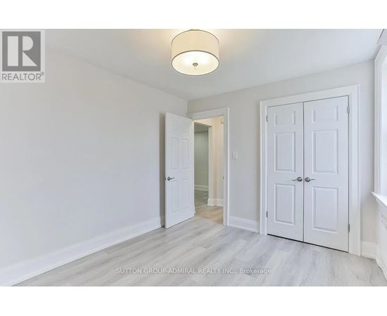 A white door is open in a room with a light on the ceiling.