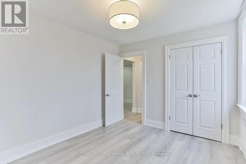 A white door is open in a room with a light on the ceiling.