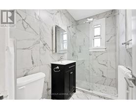 A bathroom with marble walls and a black cabinet.