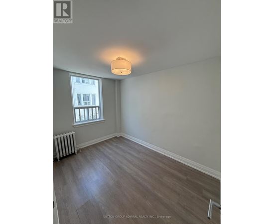 A room with a window and a radiator on the floor.