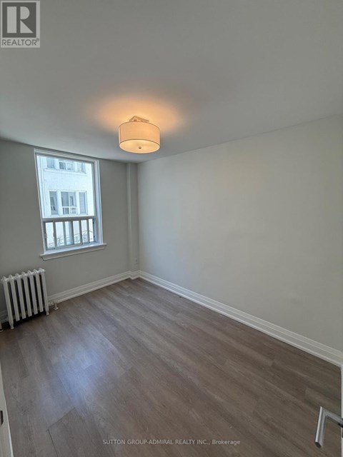 A room with a window and a radiator on the floor.